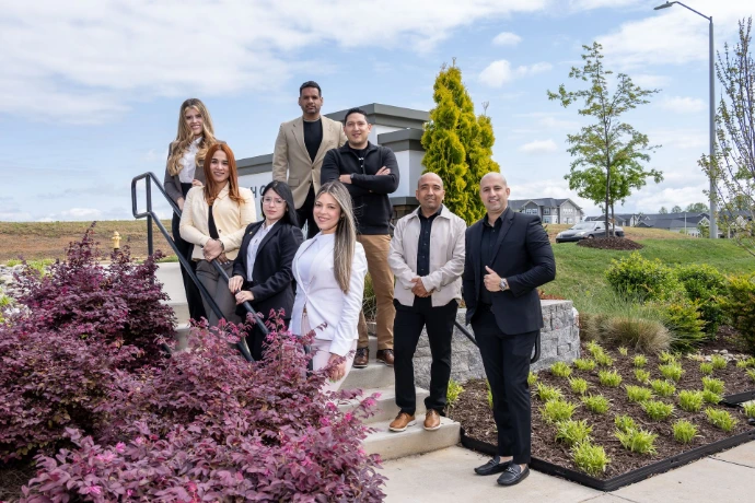 "Equipo de trabajo posando frente a las oficinas de la empresa."