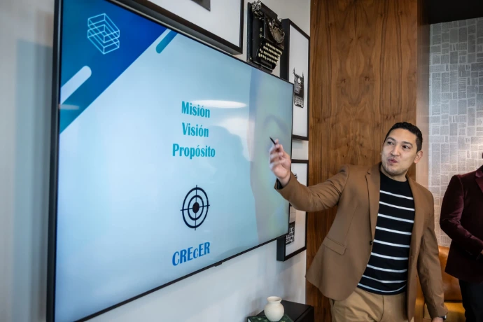 Especialista de Synergy Group realizando presentación técnica en pantalla digital.